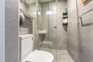 a bathroom with a toilet and a glass shower at Chic Single Room - AC - Next to Central Station - Nearby CBD USYD UTS Top Viewed Bistros - Shared Bathroom in Sydney +30 photos