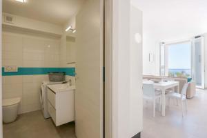 una cucina bianca con tavolo e una sala da pranzo di Guest House MareLuna a Carloforte Altre 27 foto