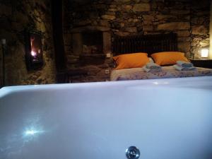 a bath tub in a room with a bed at Hotel Rural Bermellar in Bermellar