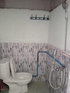 a bathroom with a toilet and a shower at Fun Family Guest House n Jungle Tour in Bukit Lawang