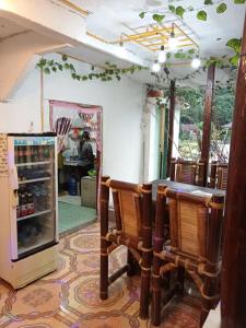 a room with a table and chairs and a refrigerator at Fun Family Guest House n Jungle Tour in Bukit Lawang