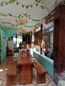un restaurante con una mesa de madera en una habitación en Fun Family Guest House n Jungle Tour en Bukit Lawang