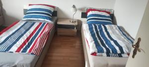 2 łóżka pojedyncze w pokoju z szafką nocną w obiekcie Zum Flughafen w mieście Düsseldorf