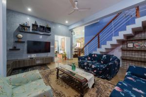een woonkamer met een bank en een tv bij LikeMyVilla 3bedroom villa in Vānivilāsa Puram