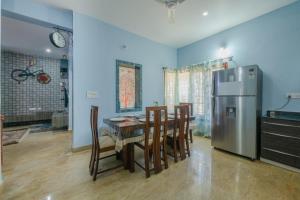 een keuken met een tafel met stoelen en een koelkast bij LikeMyVilla 3bedroom villa in Vānivilāsa Puram