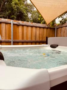 a hot tub in a backyard with a wooden fence at Townhome with Hot Tub-Grand Ways Stay- Clarissa Pl in Garland