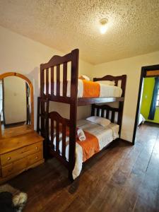 سرير بطابقين أو أسرّة بطابقين في غرفة في Garden House Hostal