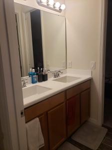 ein Badezimmer mit einem weißen Waschbecken und einem Spiegel in der Unterkunft Troy@Kissimme in Kissimmee
