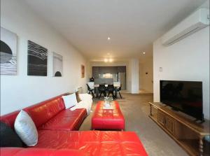 格伦韦弗利GW24-1 BATH 2 BR at The Glen with FREE Parking and Balcony的客厅配有红色沙发和平面电视