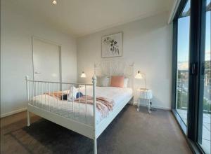格伦韦弗利GW24-1 BATH 2 BR at The Glen with FREE Parking and Balcony的卧室里有一张白色的床和一扇大窗户