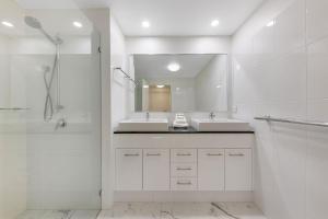 un bagno bianco con due lavandini e uno specchio di Pandanus Mooloolaba a Mooloolaba