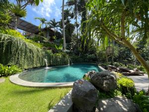 une petite piscine dans un jardin arboré dans l'établissement The Ubāri Bali - Luxury Riverside Escape, à Ubud