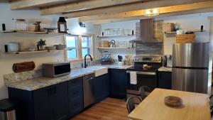 a large kitchen with blue cabinets and a wooden table at Sequoia Glen in Wilsonia