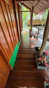 einen Holzsteg, der zu einer Veranda mit Pflanzen führt in der Unterkunft Nyande Raja Ampat in Pulau Mansuar