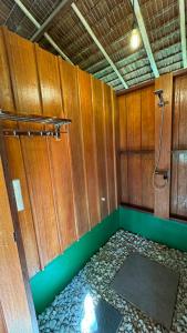 La salle de bains est pourvue de murs en bois et d'une douche. dans l'établissement Nyande Raja Ampat, à Pulau Mansuar