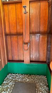 La salle de bains est pourvue d'une douche et d'un mur en bois. dans l'établissement Nyande Raja Ampat, à Pulau Mansuar