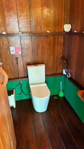 a bathroom with a toilet in a wooden room at Nyande Raja Ampat in Pulau Mansuar