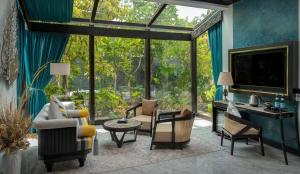a living room with a large glass window and furniture at Amara Private Villa in Siem Reap