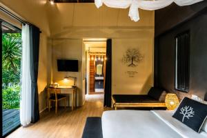 1 dormitorio con cama, sofá y TV en The Mangrove by Blu Monkey Phuket, en Panwa Beach