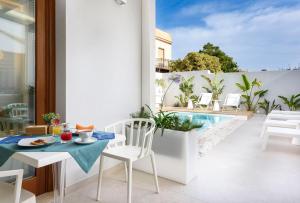 a balcony with a table and chairs and a swimming pool at Andromeda Hotel in San Vito lo Capo
