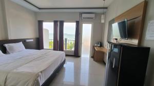 a bedroom with a bed and a flat screen tv at New Bandengan Beach Hotel in Jepara +59 photos