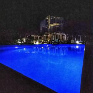 a swimming pool at night with a city in the background at Villa Regina Serafina in Balchik