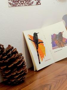 Un libro con un pájaro al lado de una piña. en Espacio Índigo - Hospedaje y Tours -, en San Luis