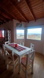 a dining room with a white table and chairs at Mil5inco Al Lago in El Calafate