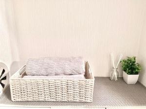 a wicker basket sitting on a floor with a plant at Ikebukuro Sugamo 駅近 A4 in Tokyo