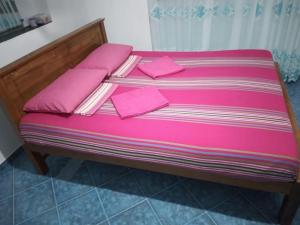 ein Bett mit rosa Bettwäsche und rosa Kissen darauf in der Unterkunft 4Seasons Holiday Home in Ratnapura
