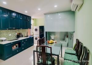 a kitchen with green cabinets and a table and chairs at Niah Cozy Home - Train Street in Hanoi