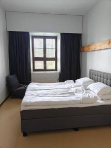 Una cama grande en un dormitorio con ventana. en Majoitus Fox, en Kuopio