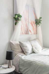 una camera da letto con un letto con lenzuola e poster bianchi di Modern Double Studio Room - AC - 1Mins to Central - Nearby Most Sydney Hotspots a Sydney