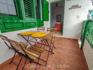 uma mesa e cadeiras num quarto com portas verdes em Casa mar y cielo em Playa Blanca