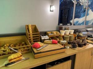 a counter with bread and other food items on it at Cit'Hôtel le Welcome in Moutiers