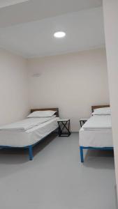 - 2 lits dans une chambre aux murs blancs dans l'établissement Пансионат Нептун, à Korumdy