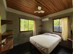 a bedroom with a bed and a wooden ceiling at Don Jon's Surf and Yoga Lodge in Santa Teresa Beach