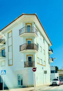 un edificio bianco con balconi e un cartello stradale di El Faro a Jávea