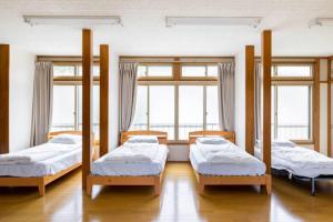 a room with three bunk beds and two windows at ザホテル湯沢パラディーソ in Yuzawa