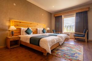 a bedroom with a large bed and a large window at The Saraha in Leh