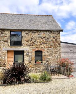 a stone house with two chairs and a balcony at Cottage Le Phare - Le Clos de la Morière in Mont-Dol