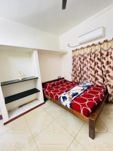 a bedroom with a red bed in a room at Lumina Home Stay in Puducherry