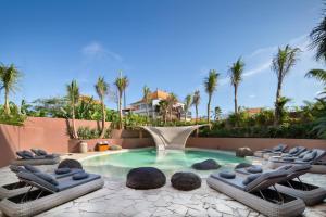 una piscina con tumbonas y una fuente en Seascape Resort & Spa Sanur by Ini Vie Hospitality, en Sanur