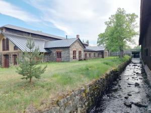 a row of buildings with a stone wall next to a field at Charming and rural cottage in Ockelbo in Ockelbo