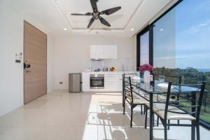 a kitchen with a dining table and a ceiling fan at Scenic sea view Apt near 3 beaches in South Patong in Patong Beach