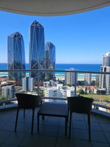 a balcony with chairs and a view of the city at Ocean View Studio Apt - Surfer's Paradise in Gold Coast