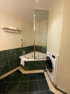 a bathroom with a tub and a washing machine at Ocean View Studio Apt - Surfer's Paradise in Gold Coast