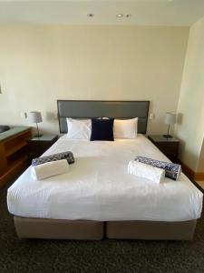 a bedroom with a large white bed with two pillows at Ocean View Studio Apt - Surfer's Paradise in Gold Coast