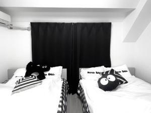 two beds with stuffed animals on them in a room at Ikebukuro Sugamo 駅近 C02 in Tokyo
