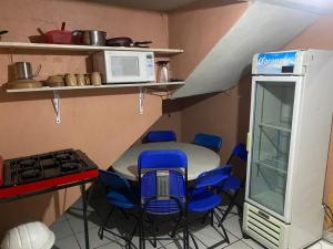 a small kitchen with a table and chairs and a microwave at Hotel Plaza in San Martín Texmelucan de Labastida